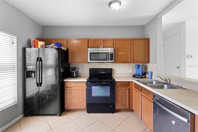 1040 Cannock Dr, Kissimmee, FL 34758 - kitchen with black appliances, light countertops, light tile patterned flooring, backsplash, and brown cabinetry