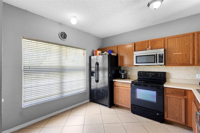 1040 Cannock Dr, Kissimmee, FL 34758 - kitchen with black appliances, a textured ceiling, brown cabinetry, backsplash, and light countertops