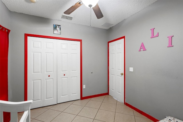 1040 Cannock Dr, Kissimmee, FL 34758 - unfurnished bedroom featuring a textured ceiling, light tile patterned floors, a closet, and a ceiling fan