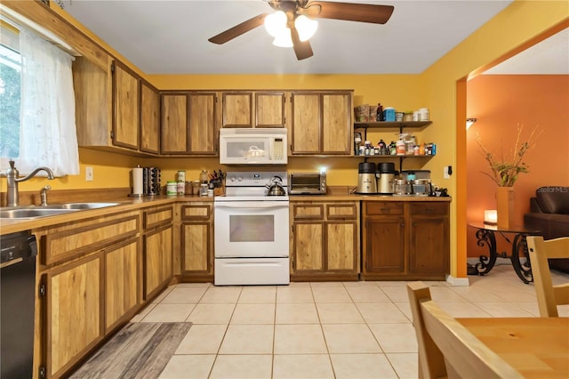 4235 Fay Blvd, Cocoa, FL 32927 - kitchen with white appliances, brown cabinetry, a ceiling fan, and light tile patterned floors