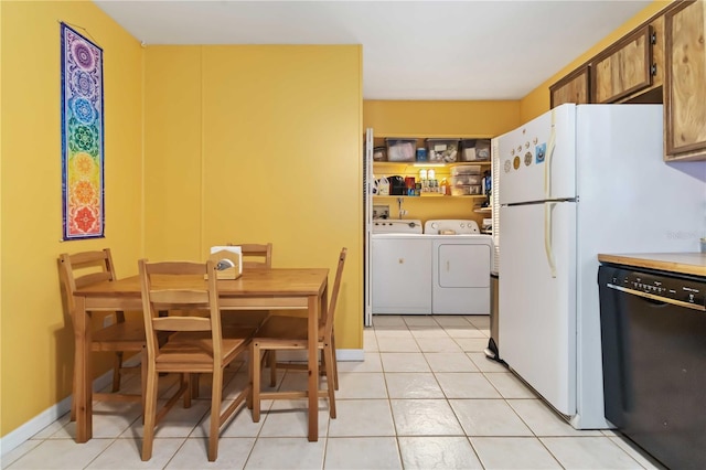 4235 Fay Blvd, Cocoa, FL 32927 - kitchen featuring black dishwasher, washing machine and dryer, light tile patterned floors, light countertops, and freestanding refrigerator