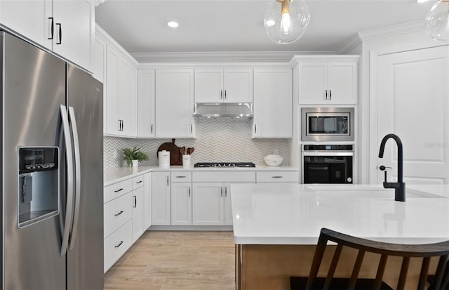8267 Fenton St, Orlando, FL 32836 - kitchen featuring stainless steel appliances, under cabinet range hood, crown molding, light countertops, and white cabinets