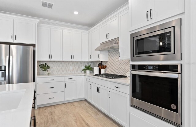 8267 Fenton St, Orlando, FL 32836 - kitchen featuring stainless steel appliances, under cabinet range hood, light countertops, white cabinetry, and recessed lighting