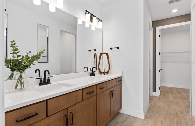 8267 Fenton St, Orlando, FL 32836 - bathroom with double vanity, wood finished floors, and a spacious closet