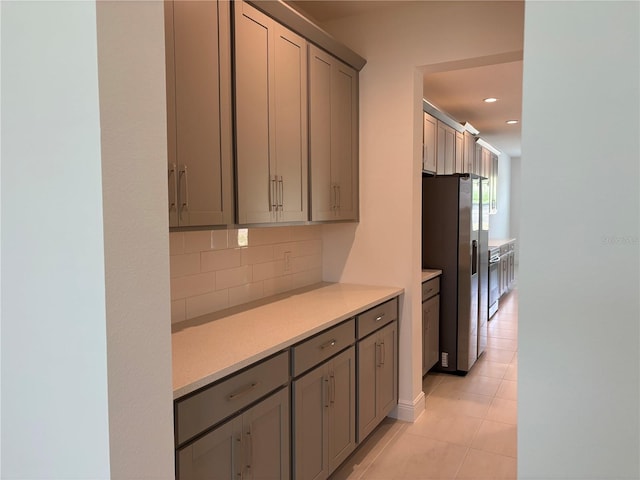7260 Dilly Lake Ave, Groveland, FL 34736 - kitchen with stainless steel fridge with ice dispenser, light countertops, decorative backsplash, gray cabinetry, and light tile patterned flooring