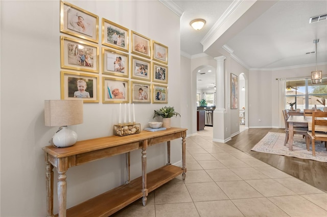 2018 Bay Clover Dr, Winter Garden, FL 34787 - hallway with crown molding, arched walkways, light tile patterned flooring, healthy amount of natural light, and decorative columns
