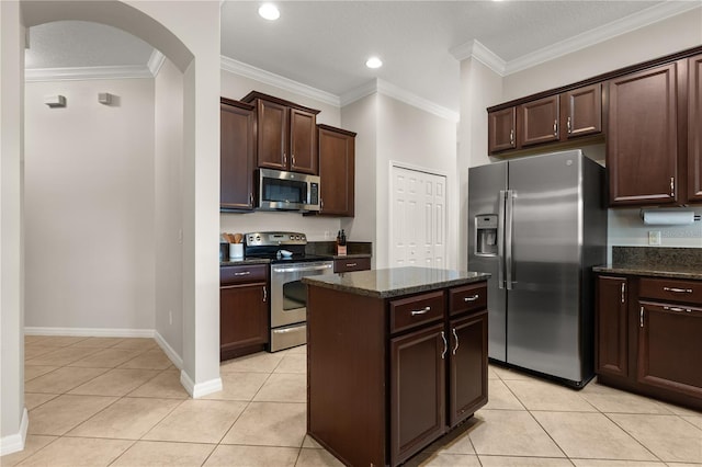 2018 Bay Clover Dr, Winter Garden, FL 34787 - kitchen featuring stainless steel appliances, light tile patterned floors, arched walkways, a center island, and ornamental molding