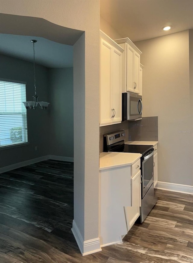 2435 Standing Rock Cir, Oakland, FL 34787 - kitchen featuring stainless steel appliances, a chandelier, white cabinets, dark wood finished floors, and light countertops