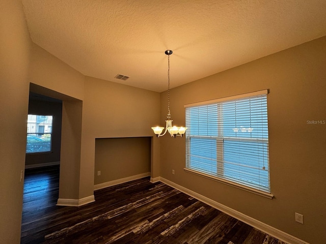 2435 Standing Rock Cir, Oakland, FL 34787 - unfurnished dining area featuring dark wood finished floors, a chandelier, and a textured ceiling