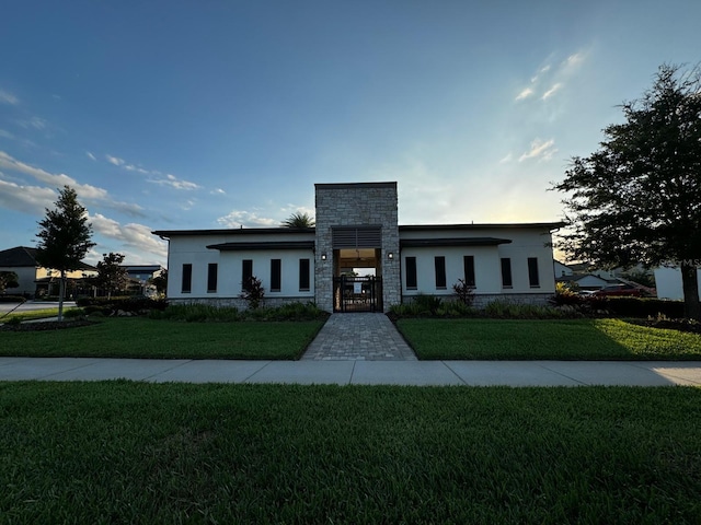 2435 Standing Rock Cir, Oakland, FL 34787 - modern home with stone siding, stucco siding, a gate, and a front lawn
