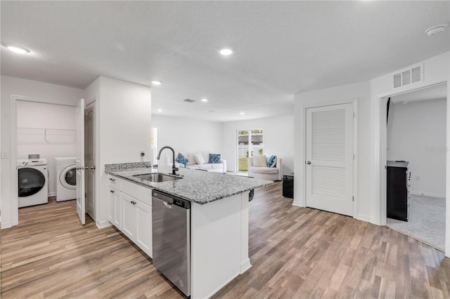 40 Briarvue Ln, Palm Coast, FL 32137 - kitchen featuring stainless steel dishwasher, washer and clothes dryer, light stone countertops, white cabinetry, and light wood finished floors