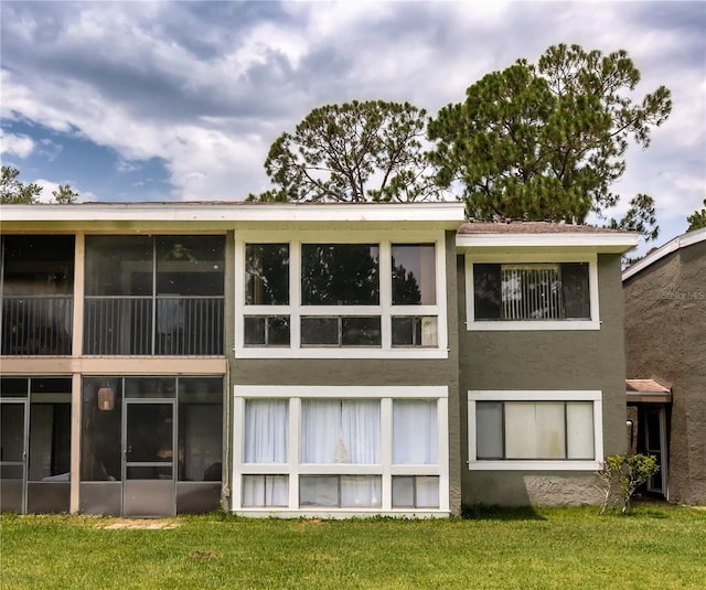 6019 Windhover Dr Unit C10-2, Orlando, FL 32819 - rear view of house featuring stucco siding, a yard, and a sunroom