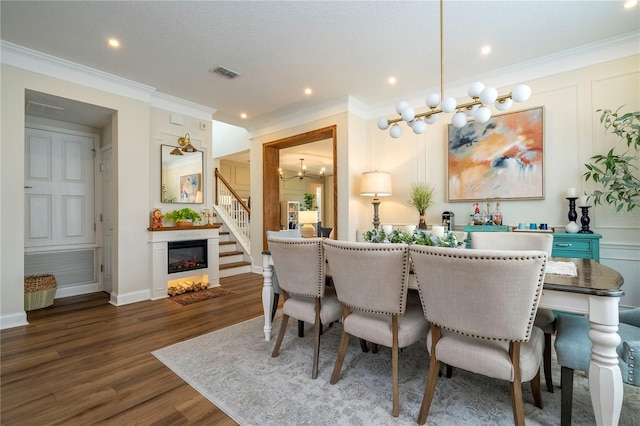 13235 Vennetta Way, Windermere, FL 34786 - dining area with wood finished floors, crown molding, recessed lighting, a glass covered fireplace, and a chandelier