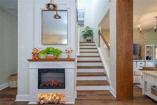 13235 Vennetta Way, Windermere, FL 34786 - stairs featuring wood finished floors, a glass covered fireplace, and a chandelier