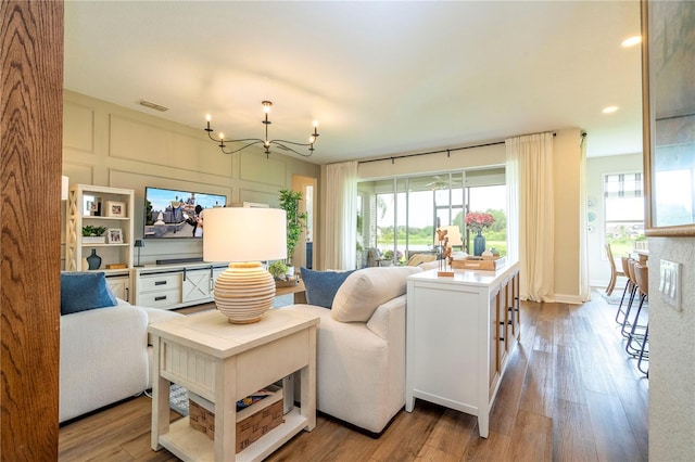 13235 Vennetta Way, Windermere, FL 34786 - living room featuring a chandelier, healthy amount of natural light, wood finished floors, and recessed lighting