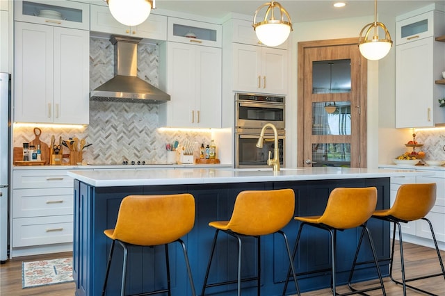 13235 Vennetta Way, Windermere, FL 34786 - kitchen with light countertops, wall chimney exhaust hood, tasteful backsplash, stainless steel double oven, and white cabinets