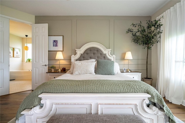 13235 Vennetta Way, Windermere, FL 34786 - bedroom featuring wood finished floors, a decorative wall, and ensuite bath