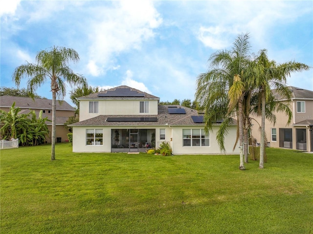 13235 Vennetta Way, Windermere, FL 34786 - rear view of house featuring roof mounted solar panels, a lawn, a sunroom, and stucco siding