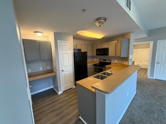 2015 Erving Cir Unit 307, Ocoee, FL 34761 - kitchen with black appliances, a peninsula, light countertops, gray cabinets, and dark wood-style flooring