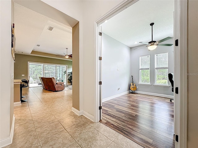 297 Shadow Ridge Trl, Ponte Vedra, FL 32081 - hallway with healthy amount of natural light, a textured ceiling, light tile patterned floors, and a tray ceiling