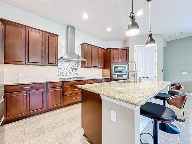 297 Shadow Ridge Trl, Ponte Vedra, FL 32081 - kitchen with wall chimney exhaust hood, stainless steel appliances, light stone countertops, tasteful backsplash, and a kitchen island with sink