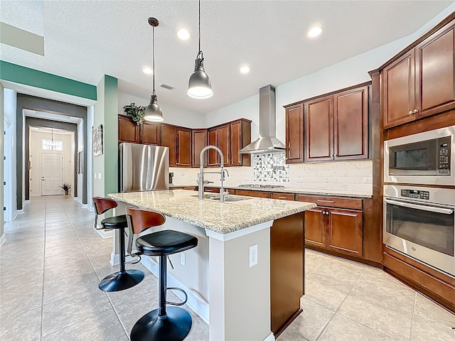 297 Shadow Ridge Trl, Ponte Vedra, FL 32081 - kitchen with stainless steel appliances, wall chimney range hood, tasteful backsplash, light stone countertops, and an island with sink