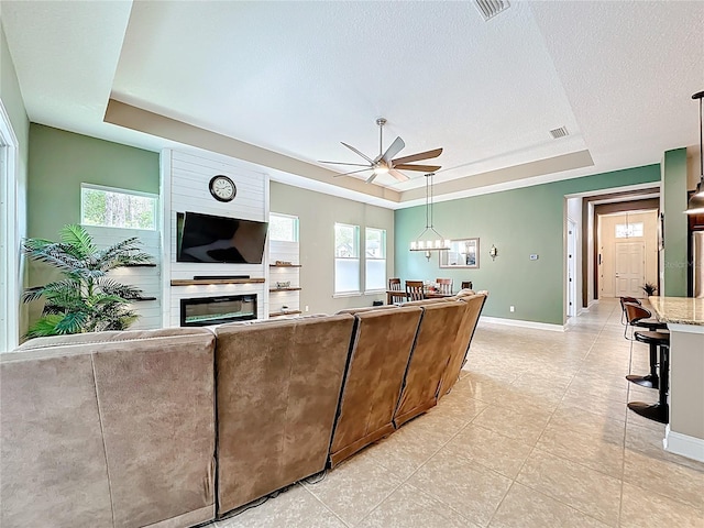 297 Shadow Ridge Trl, Ponte Vedra, FL 32081 - living area with a tray ceiling, ceiling fan, a fireplace, light tile patterned floors, and a textured ceiling