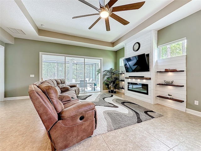 297 Shadow Ridge Trl, Ponte Vedra, FL 32081 - tiled living area featuring a raised ceiling, a ceiling fan, a textured ceiling, and a large fireplace
