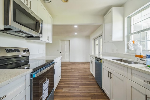 201 E 7th St, Chuluota, FL 32766 - kitchen with appliances with stainless steel finishes, dark wood-style floors, recessed lighting, white cabinets, and light stone counters