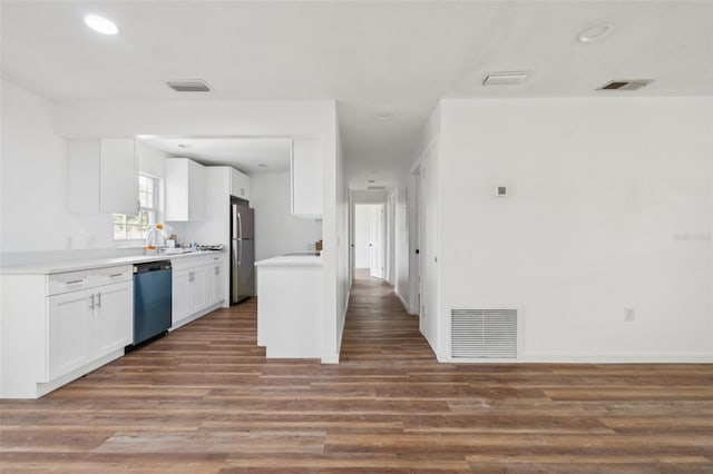 201 E 7th St, Chuluota, FL 32766 - kitchen with dishwashing machine, freestanding refrigerator, wood finished floors, white cabinetry, and light countertops