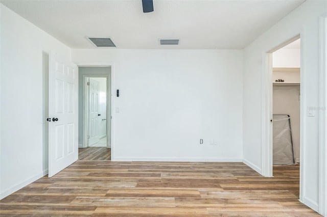 201 E 7th St, Chuluota, FL 32766 - unfurnished bedroom featuring a spacious closet, light wood-type flooring, and a ceiling fan