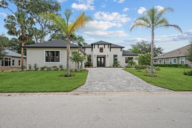 17 Old Oak Dr N, Palm Coast, FL 32137 - view of front of house featuring decorative driveway, french doors, stucco siding, and a front yard