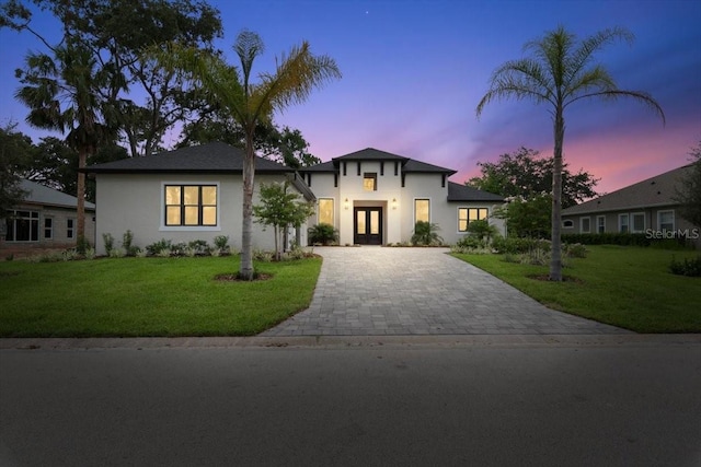 17 Old Oak Dr N, Palm Coast, FL 32137 - view of front of house with french doors, decorative driveway, stucco siding, and a yard