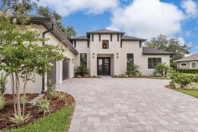 17 Old Oak Dr N, Palm Coast, FL 32137 - view of front of home with french doors, decorative driveway, stucco siding, and a garage