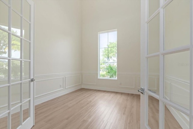 17 Old Oak Dr N, Palm Coast, FL 32137 - empty room featuring light wood finished floors, a decorative wall, and a wainscoted wall