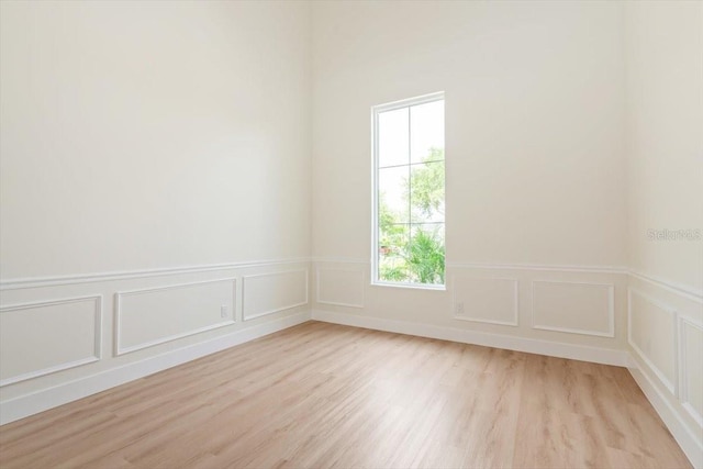 17 Old Oak Dr N, Palm Coast, FL 32137 - empty room with a decorative wall, light wood-style flooring, and a wainscoted wall