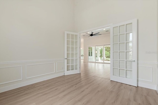 17 Old Oak Dr N, Palm Coast, FL 32137 - empty room with french doors, a decorative wall, light wood-style flooring, a towering ceiling, and ceiling fan