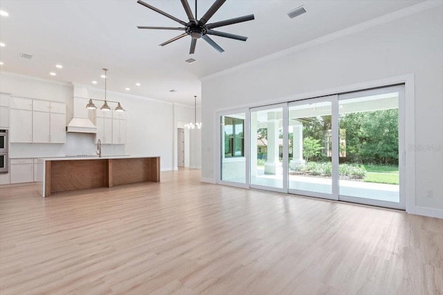 17 Old Oak Dr N, Palm Coast, FL 32137 - unfurnished living room with ornamental molding, ceiling fan, recessed lighting, light wood-style floors, and a chandelier