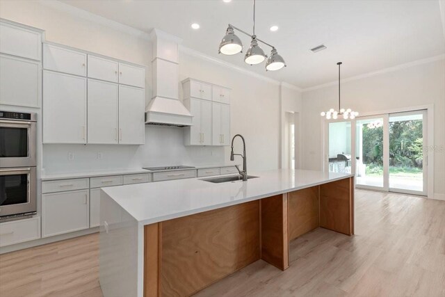 17 Old Oak Dr N, Palm Coast, FL 32137 - kitchen featuring stainless steel double oven, ornamental molding, premium range hood, light wood-style flooring, and a chandelier