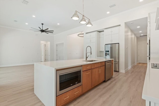 17 Old Oak Dr N, Palm Coast, FL 32137 - kitchen with stainless steel appliances, light wood finished floors, white cabinets, light countertops, and a kitchen island with sink