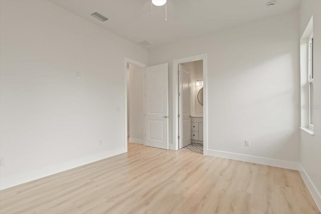 17 Old Oak Dr N, Palm Coast, FL 32137 - unfurnished bedroom featuring light wood-style flooring, ensuite bathroom, and a ceiling fan