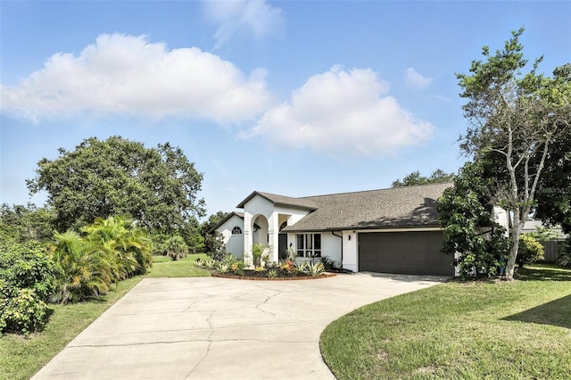 960 Falls Trl, Malabar, FL 32950 - view of front of house with driveway, stucco siding, a front yard, an attached garage, and a shingled roof
