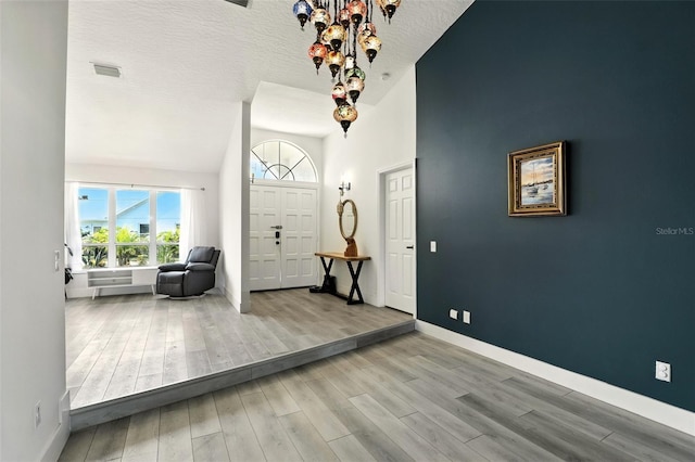 960 Falls Trl, Malabar, FL 32950 - foyer entrance with wood finished floors, high vaulted ceiling, and a textured ceiling