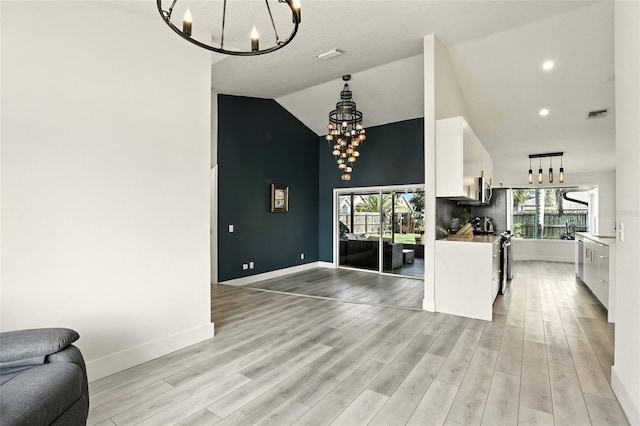 960 Falls Trl, Malabar, FL 32950 - kitchen featuring a chandelier, open floor plan, white cabinetry, stove, and light wood-type flooring