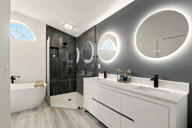 960 Falls Trl, Malabar, FL 32950 - full bathroom with lofted ceiling, a shower stall, double vanity, a freestanding tub, and wood finished floors