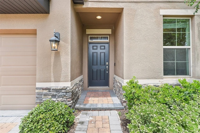 1833 Benoit Ter, Davenport, FL 33837 - doorway to property with stucco siding, stone siding, and a garage