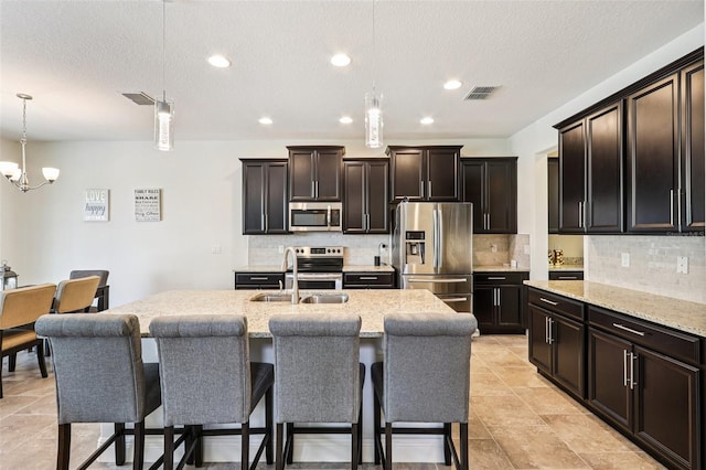 1833 Benoit Ter, Davenport, FL 33837 - kitchen featuring stainless steel appliances, hanging light fixtures, decorative backsplash, a textured ceiling, and recessed lighting