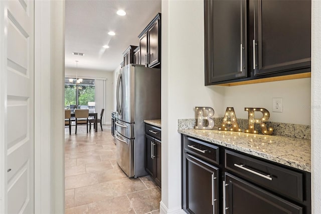 1833 Benoit Ter, Davenport, FL 33837 - kitchen featuring freestanding refrigerator, light stone counters, recessed lighting, a chandelier, and pendant lighting