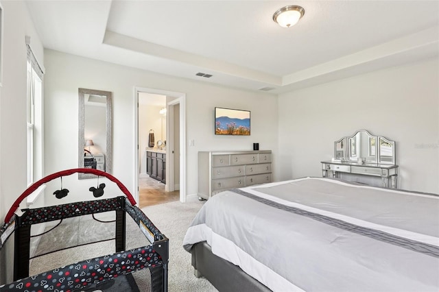 1833 Benoit Ter, Davenport, FL 33837 - bedroom featuring light colored carpet, a raised ceiling, and ensuite bath