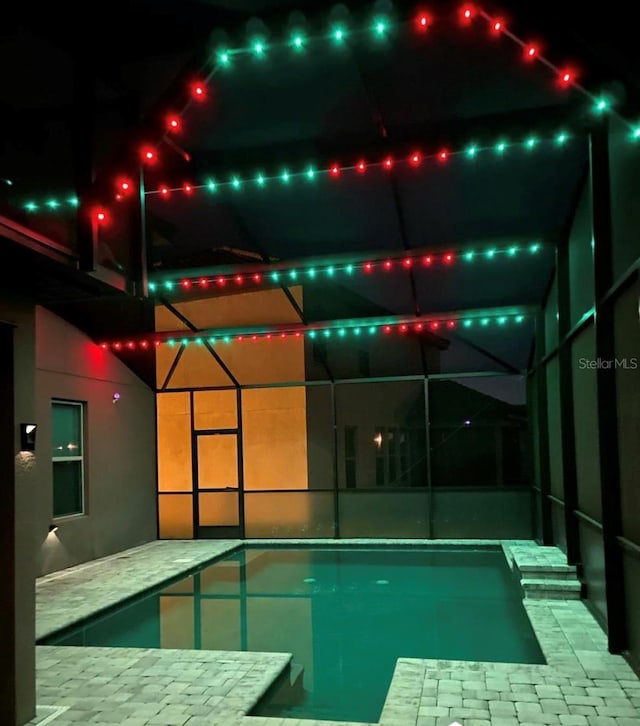 1833 Benoit Ter, Davenport, FL 33837 - pool at night featuring glass enclosure, an outdoor pool, and a patio